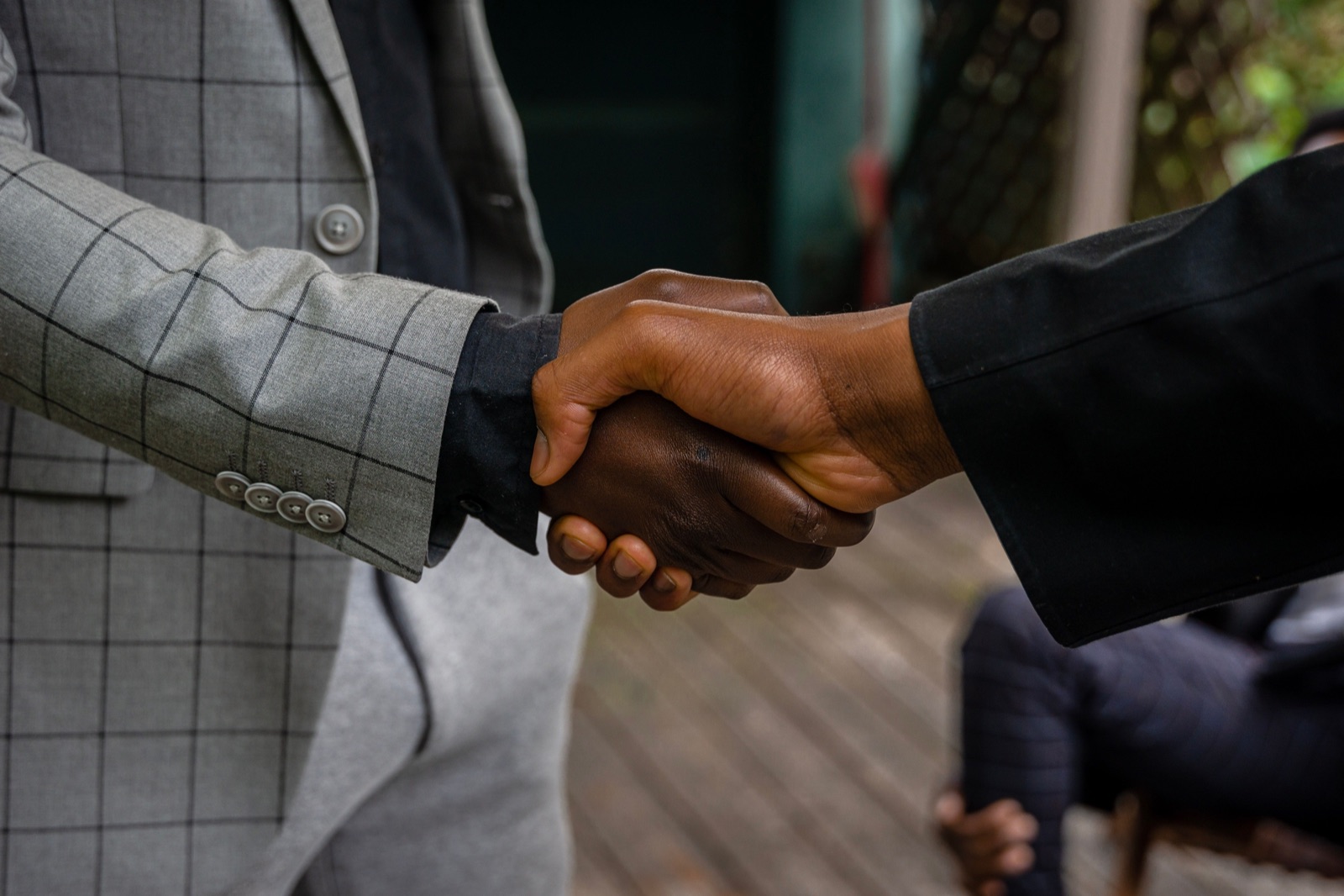 Two business partners shaking hands to close a sell-side deal
