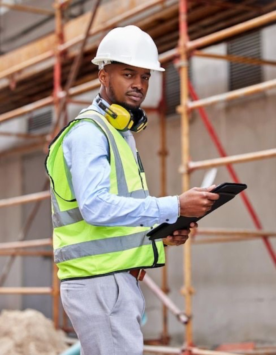 Engineer reviewing site progress on a tablet during a verification visit